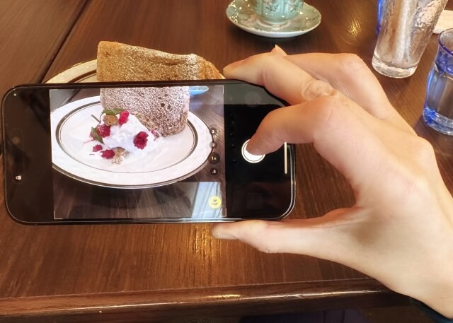 スマホでケーキの写真を撮っている　イメージ画像